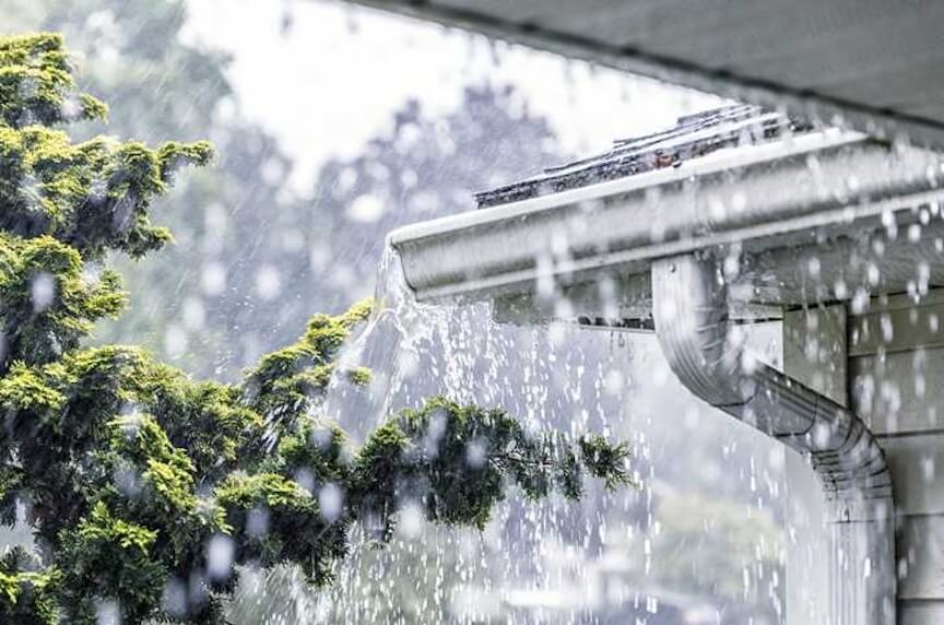 A professional using a caulking gun to seal a seam on a gutter