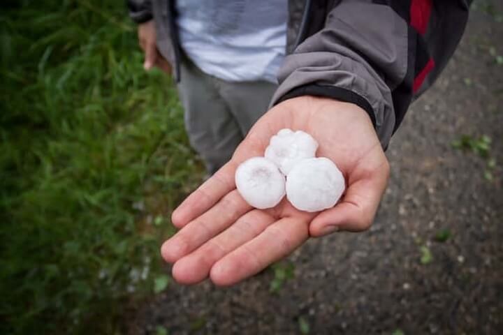 A close-up image of a gutter with visible dents from hail