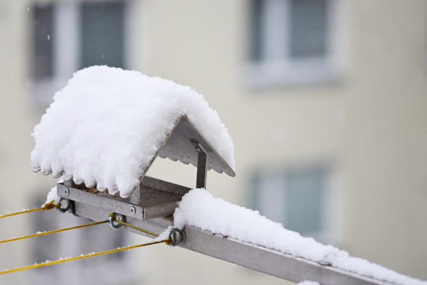 A close-up of a gutter guard covered in snow and ice during the winter