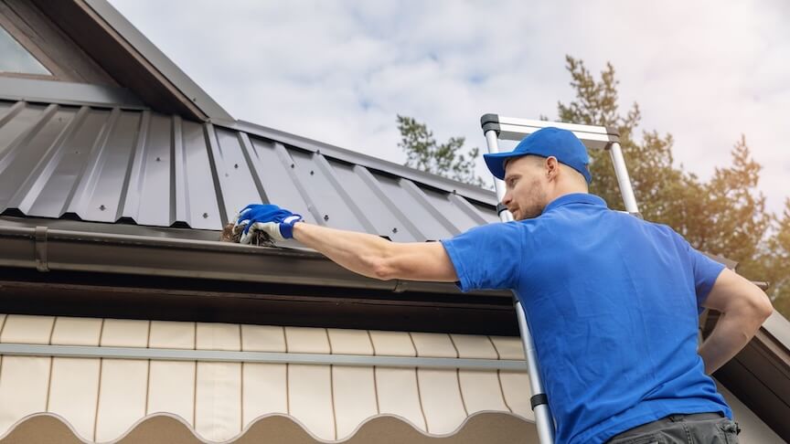 A team of gutter repair professionals working on a residential home's gutter system